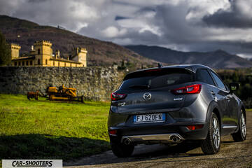 Mazda CX 3 – rear three-quarter, grey metallic against a castle and mountain backdrop