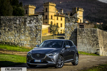 Mazda CX 3 – front three-quarter, grey metallic against a castle backdrop