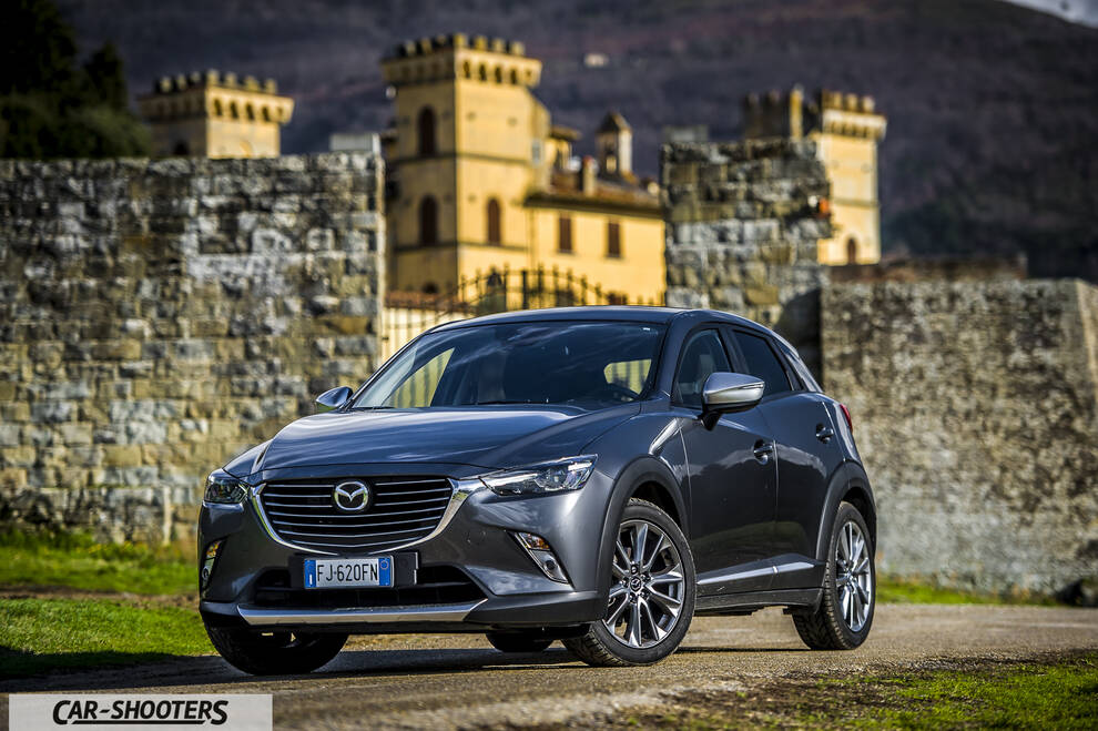 Mazda CX 3 – front three-quarter, grey metallic against a castle backdrop