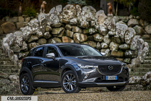 Mazda CX 3 – front three-quarter, dark grey against a stone wall backdrop