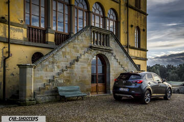 Mazda CX 3 – rear three-quarter, grey metallic against a rustic building