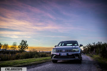 Volkswagen Tiguan – front three-quarter, silver metallic on a rural road at sunset