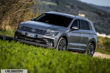 Volkswagen Tiguan – front three-quarter, grey metallic on a grassy hill