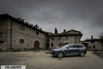 Volvo XC90 – front three-quarter, grey metallic in a medieval courtyard