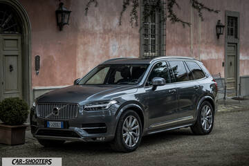 Volvo XC90 – front three-quarter, grey metallic against a rustic pink wall
