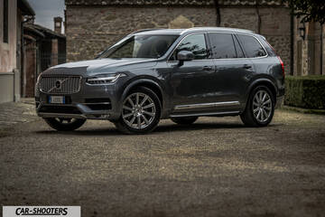 Volvo XC90 – front three-quarter, dark grey parked on an old street