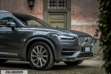 Volvo XC90 – front three-quarter, grey metallic against a rustic wall