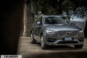 Volvo XC90 – front three-quarter, grey metallic parked near an old gate