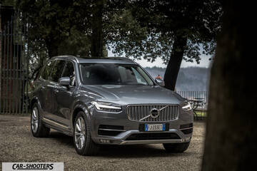 Volvo XC90 – front three-quarter, grey metallic parked near trees