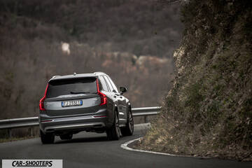 Volvo XC90 – rear three-quarter, grey metallic on a winding road