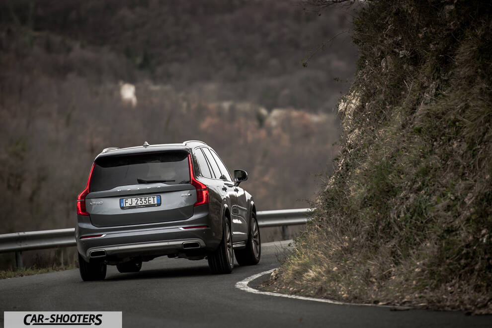 Volvo XC90 – rear three-quarter, grey metallic on a winding road