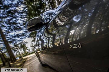 Infiniti Q50 – side profile, grey metallic on a forest road