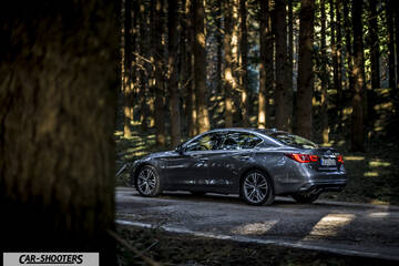 Infiniti Q50 – rear three-quarter, grey metallic in a forest