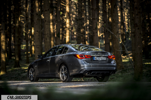 Infiniti Q50 – rear three-quarter, grey metallic in a forest
