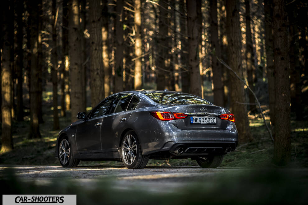 Infiniti Q50 – rear three-quarter, grey metallic in a forest