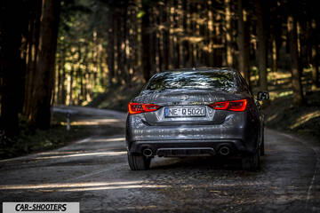 Infiniti Q50 – rear view, grey metallic on a country road