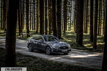 Infiniti Q50 – front three-quarter, grey metallic on a forest road