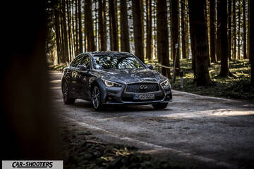 Infiniti Q50 – front three-quarter, grey metallic on a country road
