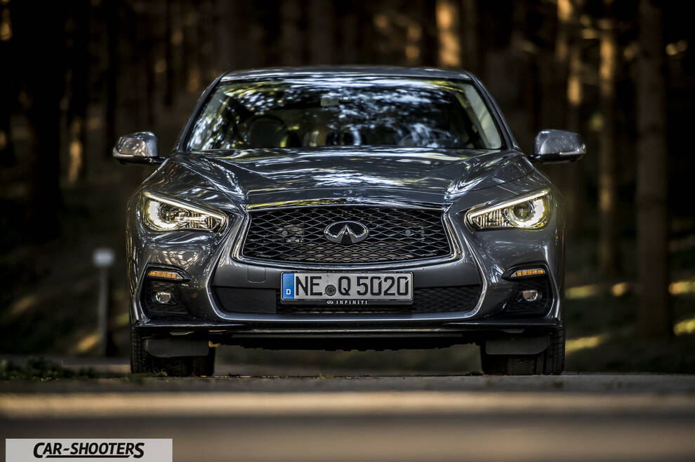 Infiniti Q50 – front three-quarter, grey metallic on a country road