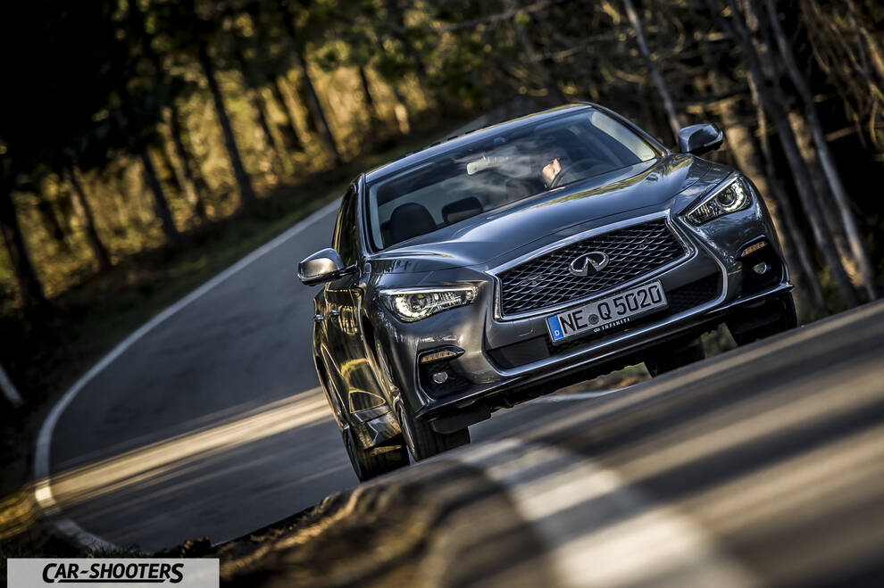 Infiniti Q50 – front three-quarter, grey metallic on a country road