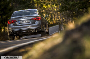 Infiniti Q50 – rear three-quarter, grey metallic on a country road