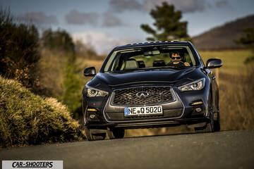 Infiniti Q50 – front three-quarter, dark grey metallic on a country road
