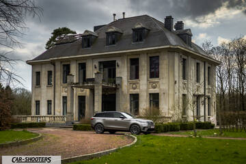 front three-quarter, silver in front of a grand mansion