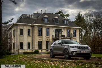 front three-quarter, silver in front of a large mansion