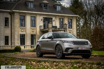 front three-quarter, silver parked in front of a large mansion