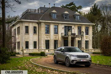 front three-quarter, silver on a driveway in front of a large mansion