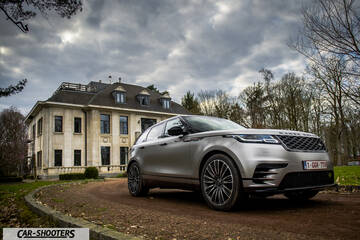 front three-quarter, silver parked in front of a large house