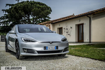 Tesla Model S – front three-quarter, silver metallic parked in a gravel driveway