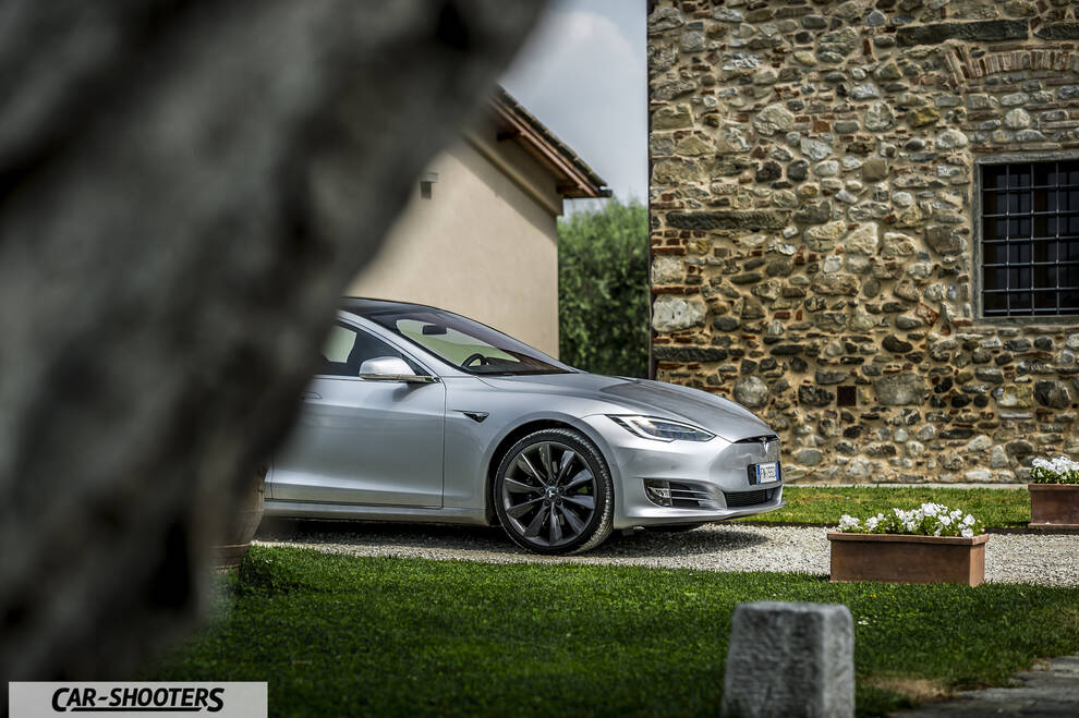 Tesla Model S – front three-quarter, silver against a stone building
