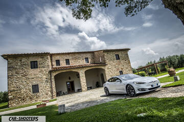 Tesla Model S – front three-quarter, silver parked in front of a stone villa
