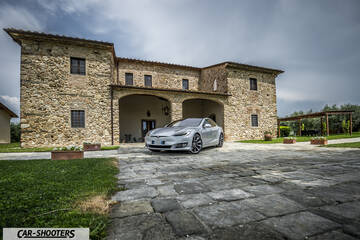 Tesla Model S – front three-quarter, silver in front of a stone building