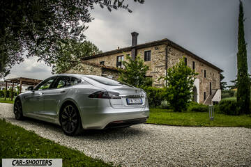 Tesla Model S – rear three-quarter, silver metallic parked on a gravel driveway