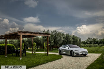 Tesla Model S – front three-quarter, silver metallic on a gravel driveway