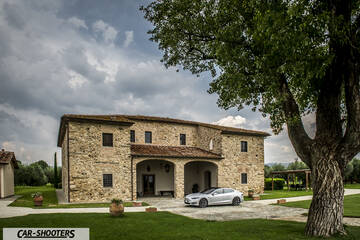 Tesla Model S – front three-quarter, silver in front of a stone building