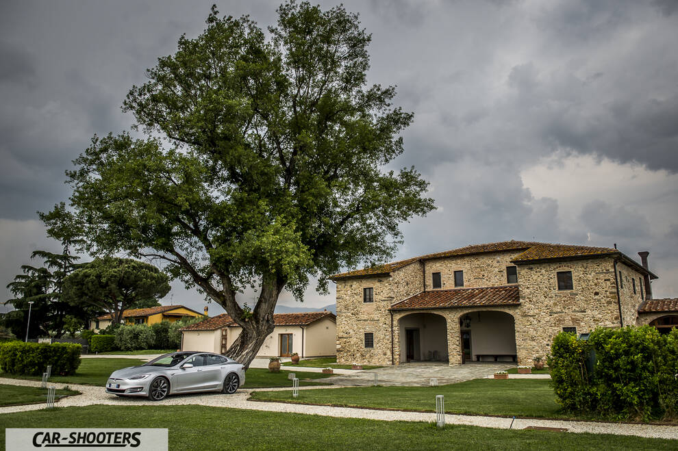 Tesla Model S – front three-quarter, silver parked near a large tree