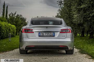 Tesla Model S – rear view, silver on a gravel driveway