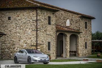 Tesla Model S – front three-quarter, silver in front of a stone building