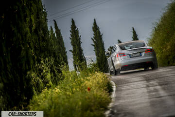 Tesla Model S – rear three-quarter, silver on a country road