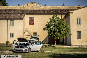 Volkswagen Golf GTI – front three-quarter, white in front of a rustic building