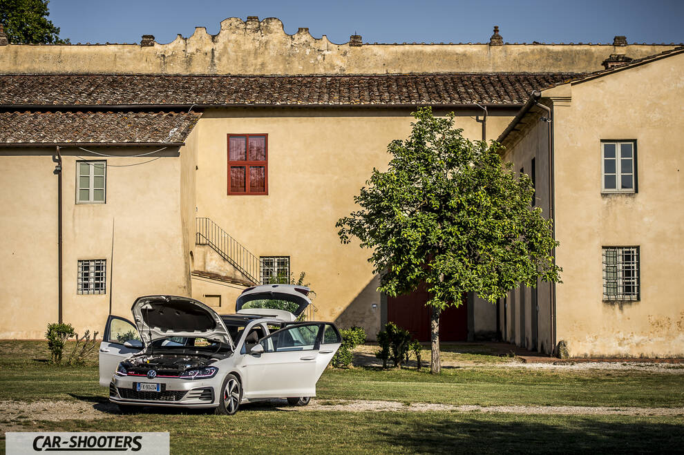 Volkswagen Golf GTI – front three-quarter, white in front of a rustic building