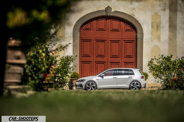 Volkswagen Golf GTI – side profile, white in front of a red arched door