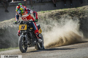 front three-quarter, black kicking up dust on a dirt track