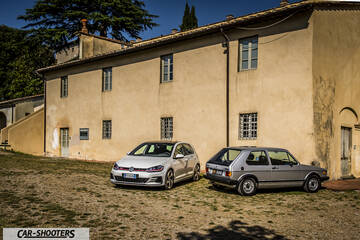 front three-quarter, silver against a rustic building wall