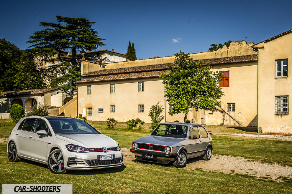 front three-quarter, silver parked against an old building