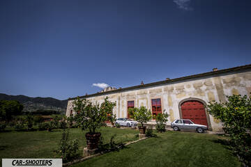 side profile, silver parked against a rustic building