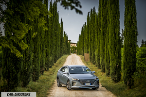 Hyundai Ioniq – front three-quarter, silver on a dirt road lined with tall trees